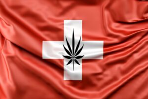 une feuille de chanvre verte juxtaposée au drapeau rouge de la Suisse